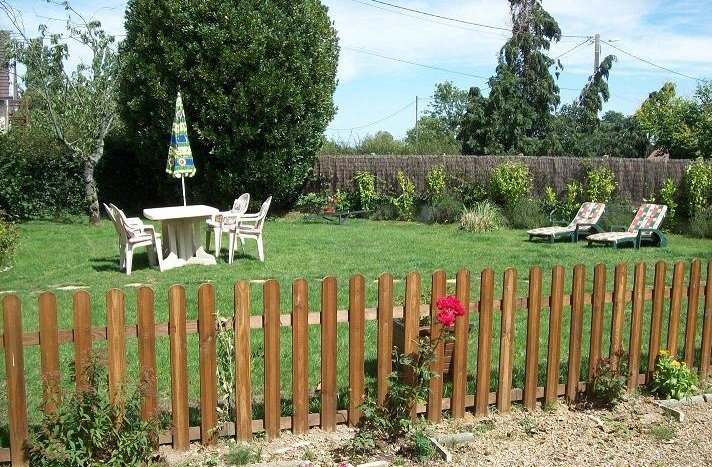 Le jardin privatif avec salon de jardin et bains de soleil
